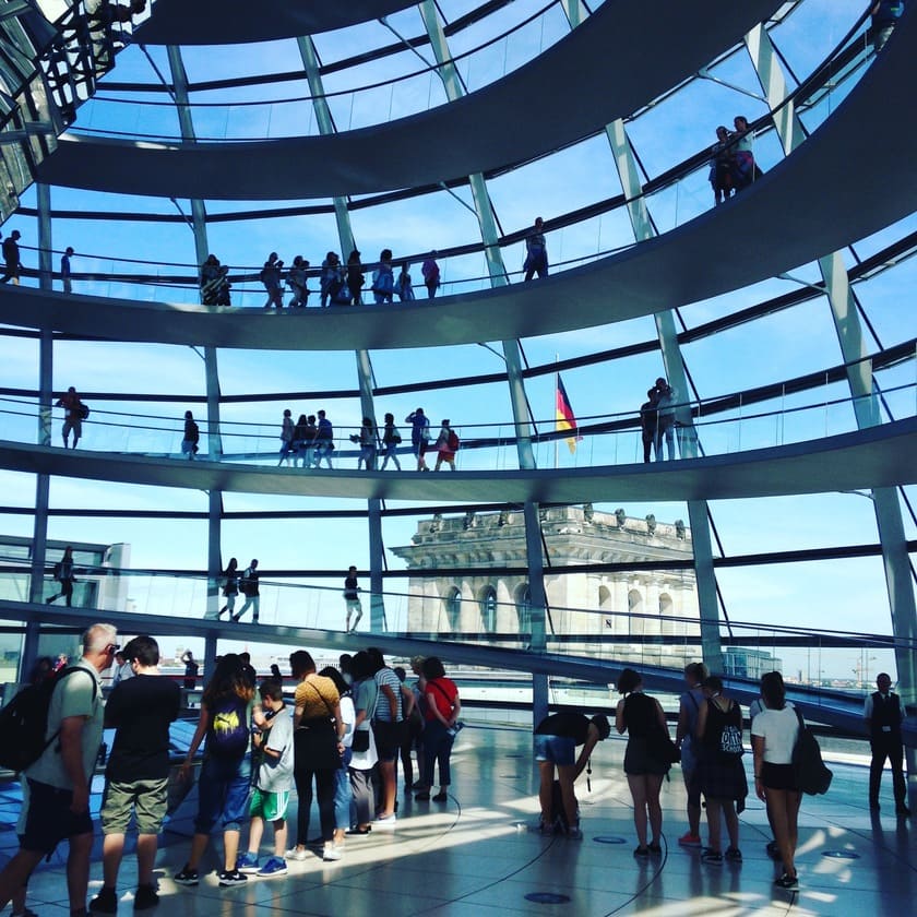 Interior de la cúpula de cristal del Reichstag en Berlín con visitantes.